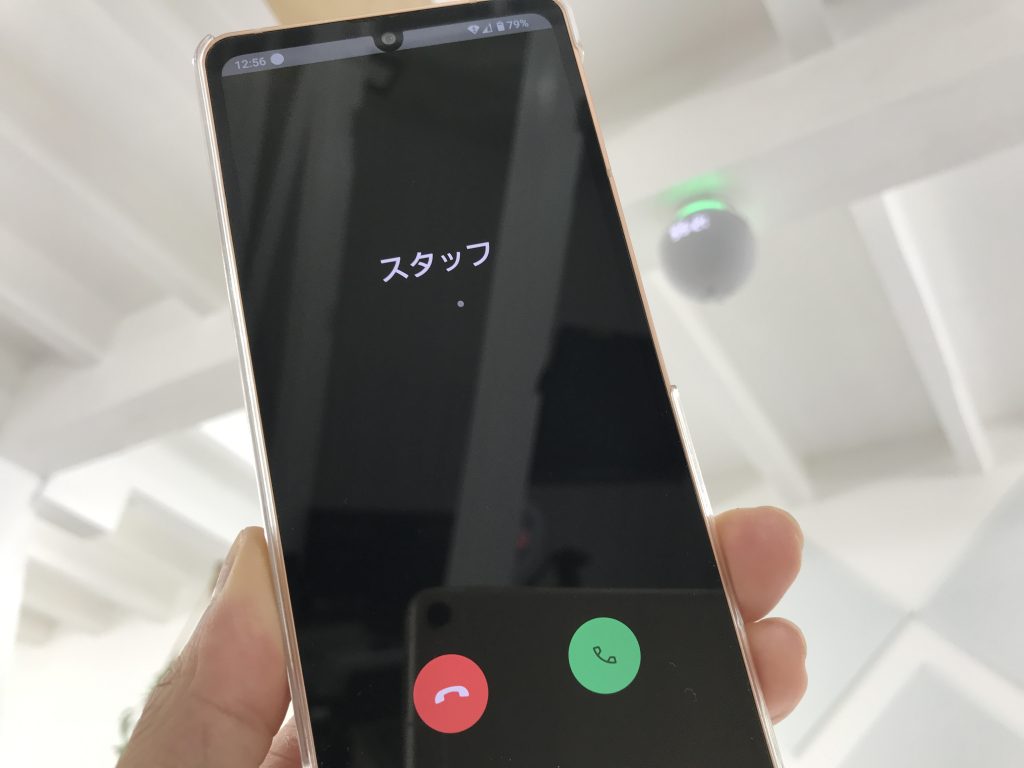 天井のスマートスピーカーと通話中の電話